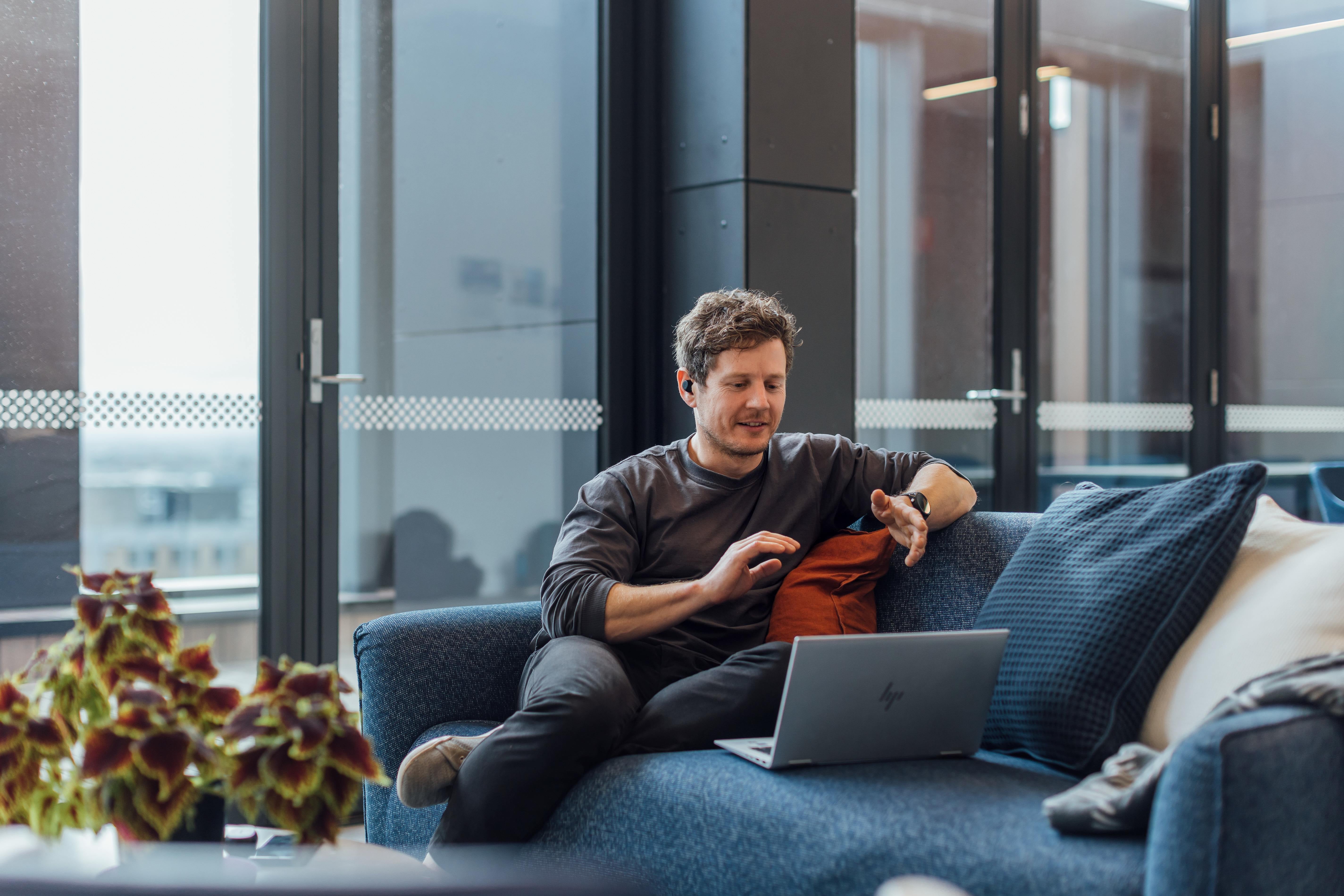 A man sitting on a couch with his laptop.