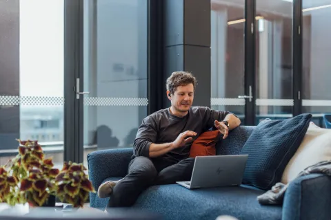 A man sitting on a couch with his laptop.