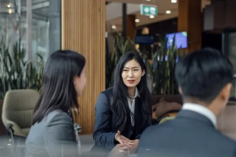 Public health professionals wearing business suits and having a discussion in a meeting room.